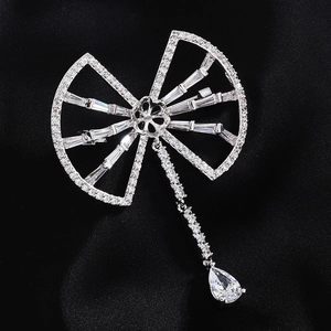 Broche en zircon argenté avec design papillon abstrait et pendentif goutte sur satin noir
