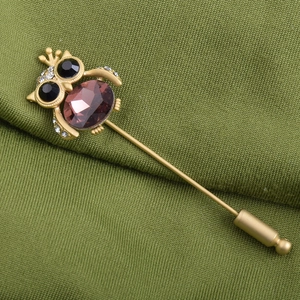 Élégante épingle hibou avec grand cristal violet et strass sur base en métal doré
