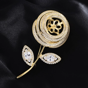 Macro view of gold flower brooch base with zircon petals and pearl mount on black silk