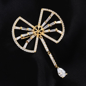 Vue macro détaillée d'une broche éventail doré avec zircons et pendentif goutte d'eau