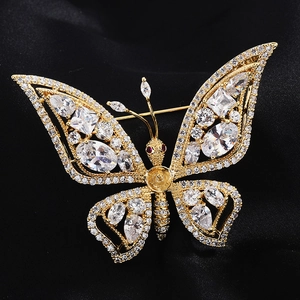 Vue macro d'une broche papillon dorée avec des ailes en zircon sur fond de soie noire
