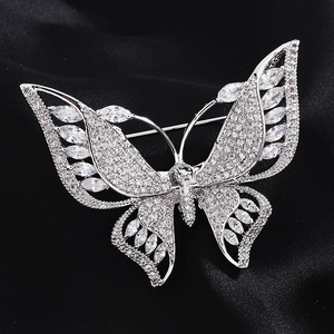 Détail macro d'une broche papillon sertie de zircons sur un tissu en soie noire élégant