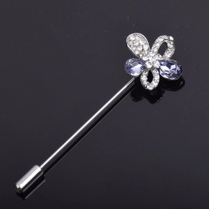 Detail of a silver stick brooch with purple teardrop crystals and small rhinestones