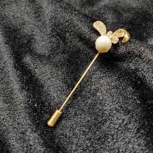 Close-up of golden rabbit long pin brooch with a large white pearl and sparkling crystals