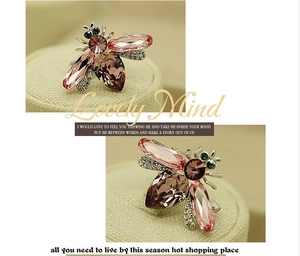 Détail macro de broche abeille avec cristaux roses et violets et strass scintillants