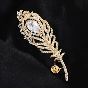 Élégante broche plume de paon dorée avec cristaux de zircon sur soie noire