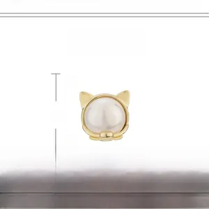 Macro detail van katvormige magnetische broche van koper-zirkon met witte parel