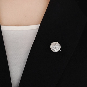 Détail d'une broche aimantée licorne argentée avec cristaux sur le revers d'un costume