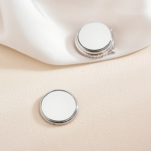 Silver magnetic brooch with Roman numerals on white silk and beige leather background