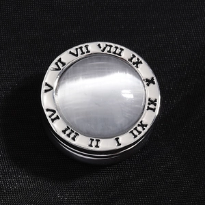 Silver magnetic brooch with roman numerals and cat eye stone on black fabric background
