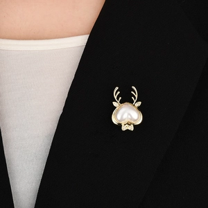 Detail of deer antler brooch with heart pearl on black blazer lapel for styling