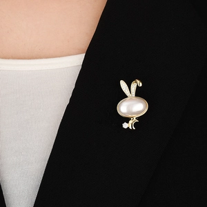 Detail of a rabbit magnetic brooch with white gemstone on a black suit lapel