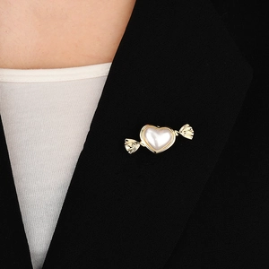 Detail of candy-shaped heart pearl magnet brooch on a black suit lapel for women