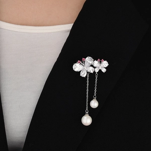 Elegant double butterfly brooch with sparkling zircons and white pearl pendants on black suit