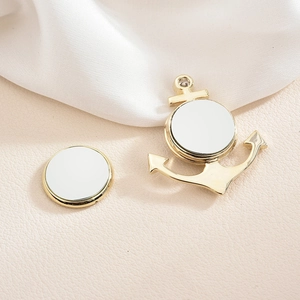 Gros plan d'un pendentif ancre doré et d'une base ronde avec inserts de sublimation DIY