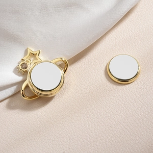 Goldene Saturn Magnet-Brosche mit Stern und Zirkonia auf Seide und Leder Hintergrund