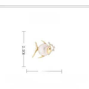 Détail macro d'une broche magnétique en forme de poisson avec zircons et perle blanche