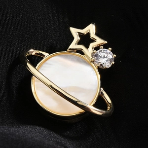Magnetische Planeten-Brosche mit goldenem Ring und Perlmutt auf schwarzer Seide