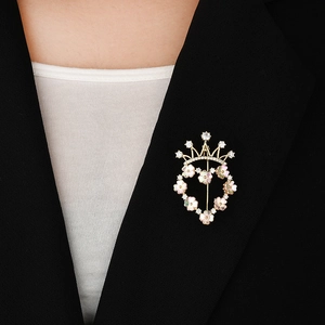 Broche couronne cœur dorée élégante avec pétales de coquillages et zircons sur veste
