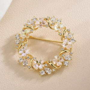 Elegant gold flower wreath brooch with sparkling round zircons and iridescent petal coating