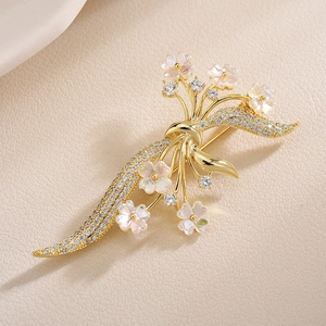 Elegante spilla a fiore dorata con petali in madreperla e accenti di zirconi lucidi