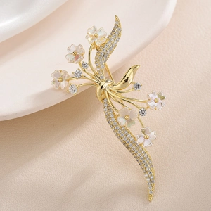 Elegante spilla a fiocco e fiori con intarsio in zirconia su base dorata