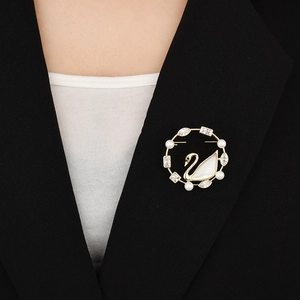 Spilla a cigno elegante con madreperla e perle su una giacca da completo nero