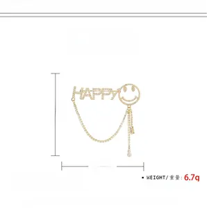 Vue détaillée de la broche HAPPY en zircon avec chaînes pendantes et pompons