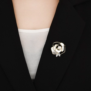 Elegant white camellia brooch with pearl and zircon detail on a black suit lapel
