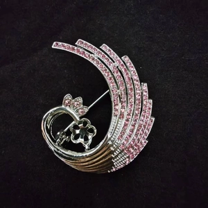 Detailed view of silver-tone alloy brooch with pink rhinestones and a floral setting base