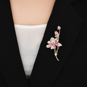 Eleganter Blumenanstecker mit Zirkonia in Rosa und Weiß auf schwarzem Sakko für Damen