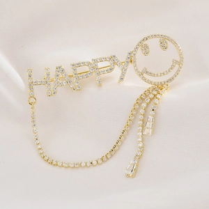 Broche HAPPY dorée avec zircone souriante et élégants pendentifs à pompons