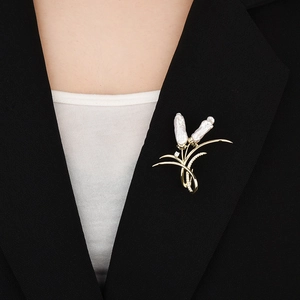 Elegant gold baroque pearl brooch with zircon accents on a professional black blazer