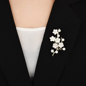 Elegante spilla a fiore in madreperla con perle bianche su revers nero, finitura oro