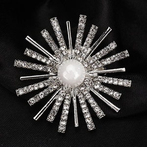 Elegant sunburst brooch with a central pearl and sparkling rhinestones on black silk