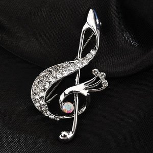 Elegant silver musical note brooch with sparkling rhinestones on black silk fabric