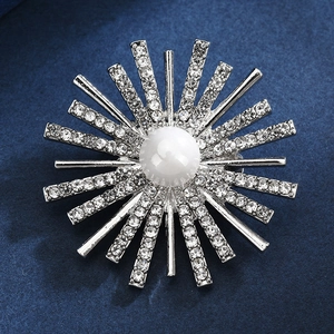 Elegant sunburst brooch with a large white pearl center and sparkling rhinestone rays