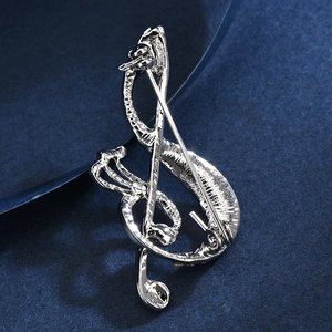 Elegant silver musical note brooch back view with rotating clasp on blue background