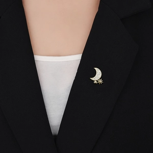 Detaillierte Nahaufnahme einer Mond und Stern Brosche am Revers eines schwarzen Blazers