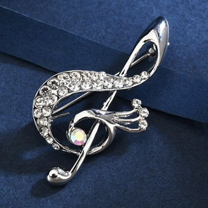 Elegant silver musical note brooch with sparkling rhinestones on dark blue background