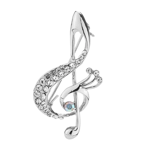 Detailed macro view of a silver treble clef brooch with sparkling crystals and rhinestones