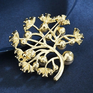 Rückansicht einer goldenen Baumbrosche mit Sicherheitsverschluss und Perlen auf Blau