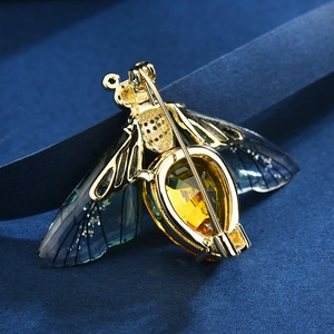 Elegant gold-tone insect brooch with amber pear-shaped gemstone and blue gradient wings
