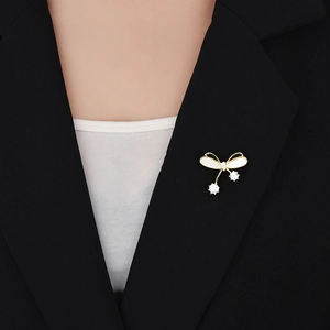 Broche nœud papillon élégante avec nacre et zircon suspendu portée sur un vêtement