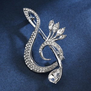 Elegant musical note brooch with silver rhinestones and teardrop crystal on blue background