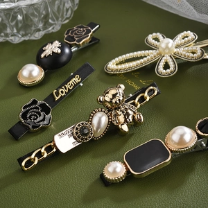 Vue détaillée de barrettes vintage françaises avec perles, roses et accents dorés élégants
