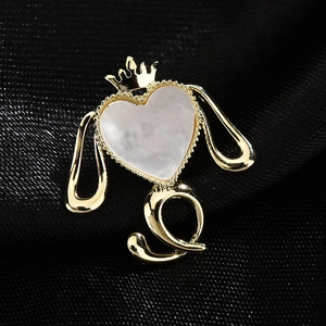 Charmante broche chiot dorée avec cœur en marbre et couronne sur fond de soie foncée