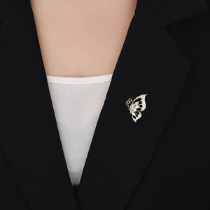 Gros plan d'une broche papillon en zircone sur un blazer noir, détails raffinés