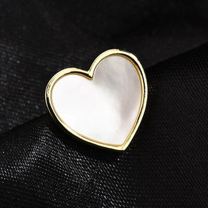 Elegant gold heart brooch with white mother of pearl inlay on black silk background