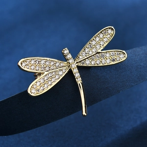 Eleganter Libellen-Anstecknadel mit weißen Zirkonia-Kristallen auf blauem Grund